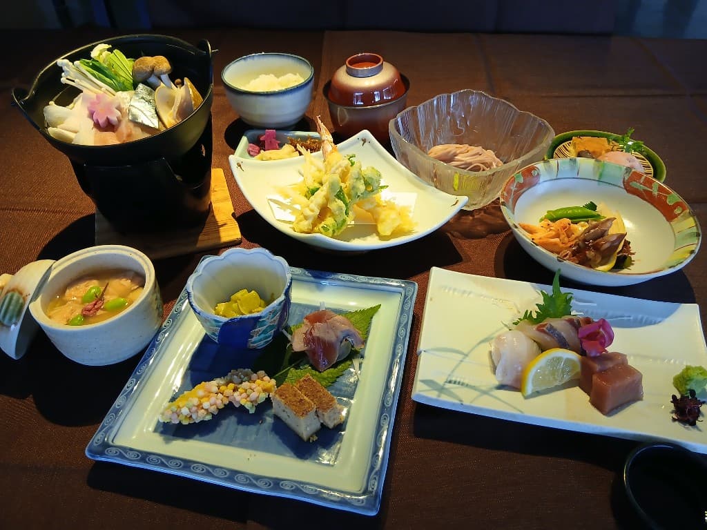 旬の食材を盛り込んだ和会席の膳。鍋料理・天ぷら・刺身・炊き合わせなど多彩な一品が卓上に並ぶ